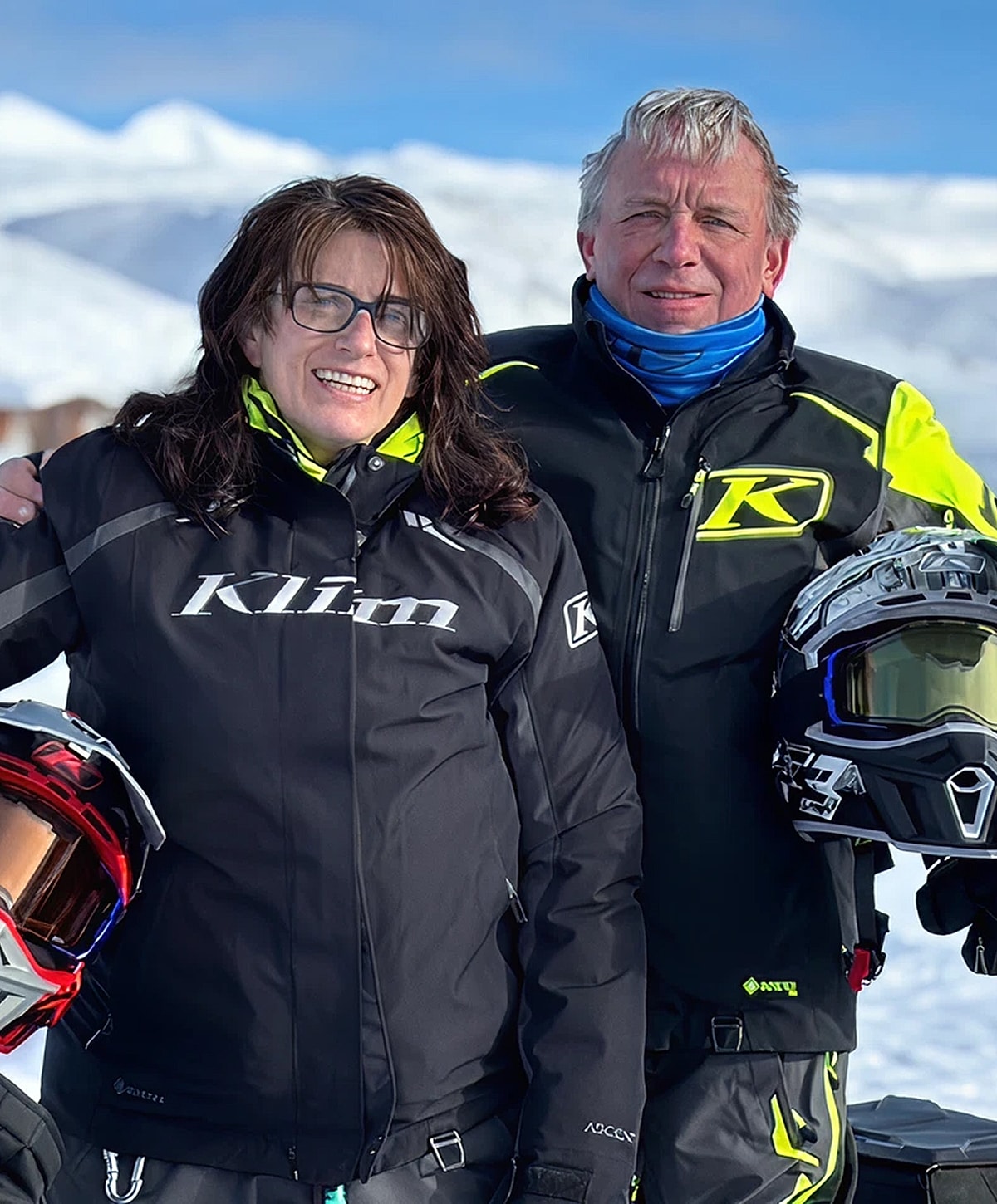Two people in winter gear on snowy landscape.