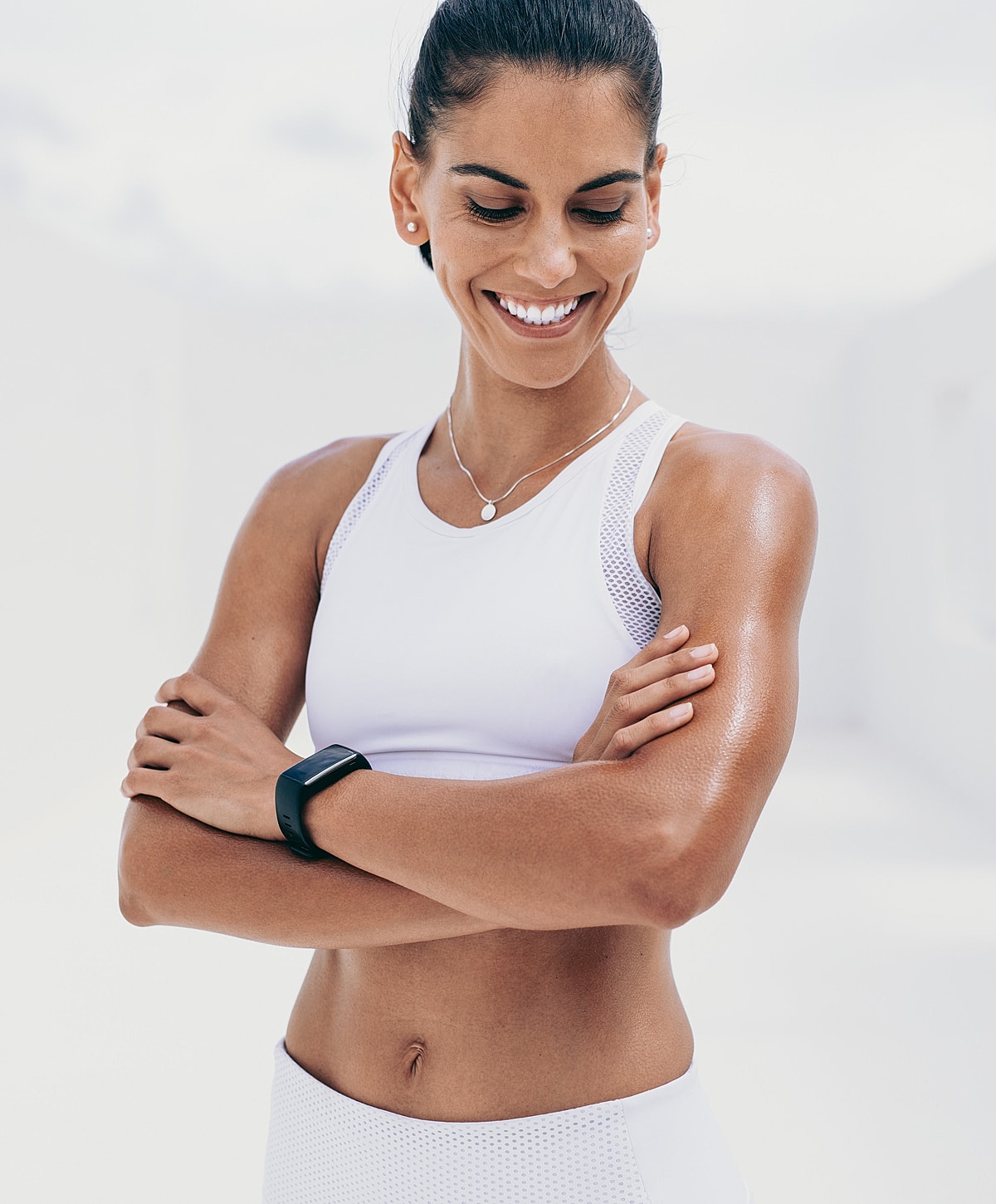 Smiling woman in athletic wear with smartwatch.