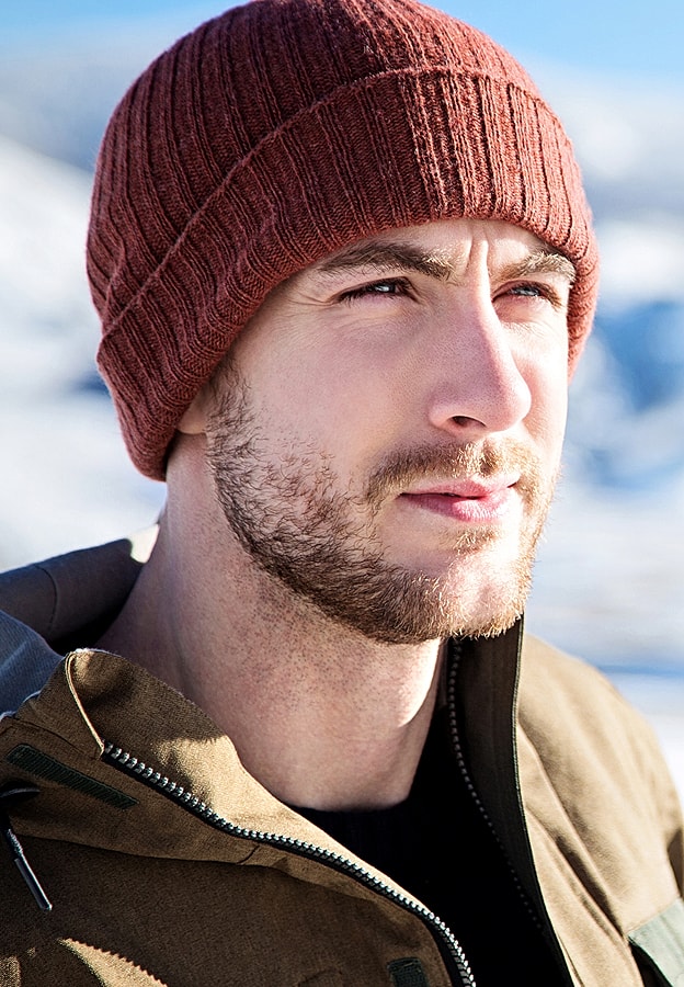 Man in winter hat against snowy background.