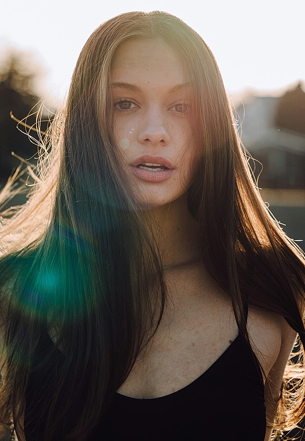Young woman with long hair in sunlight.