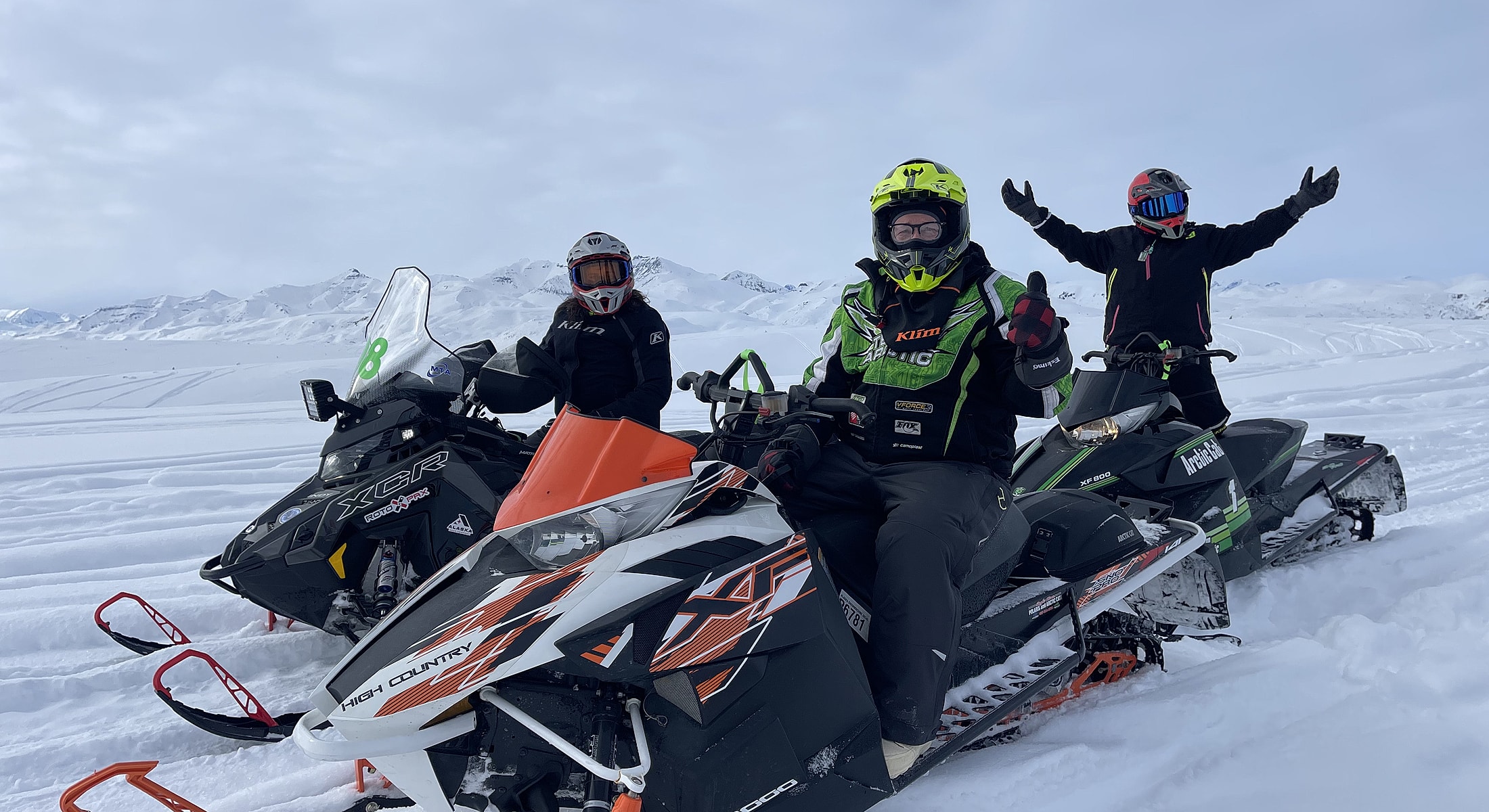 Group of friends enjoying snowmobiling in winter.